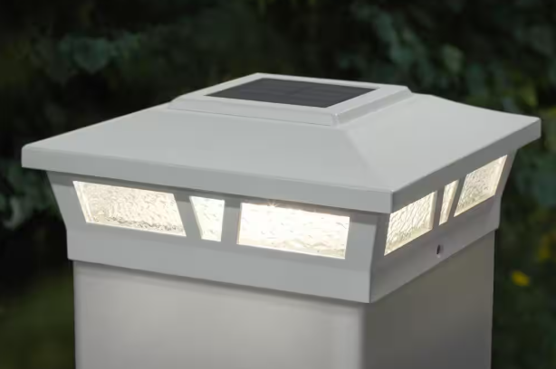 LED post cap lights illuminating deck railing posts with warm evening lighting